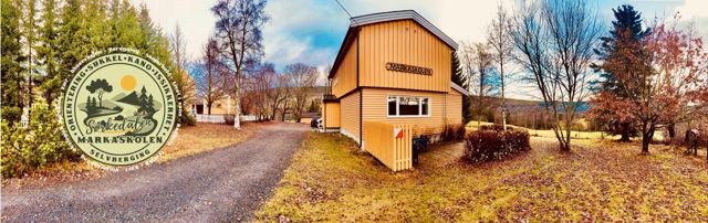 en liten bygning med et skilt foran