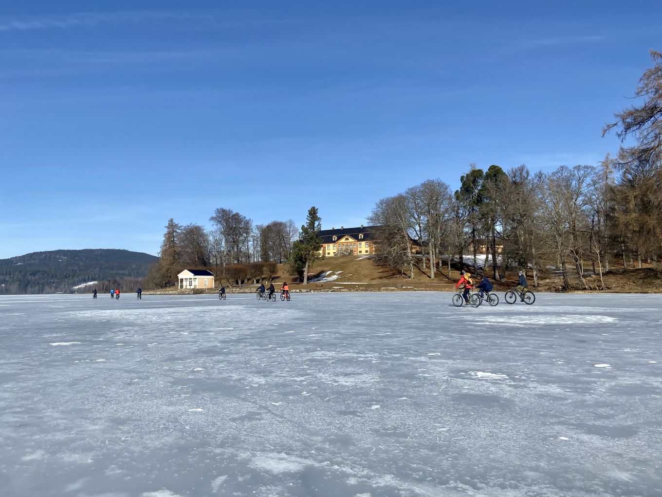 En gruppe mennesker som sykler på en frossen innsjø
