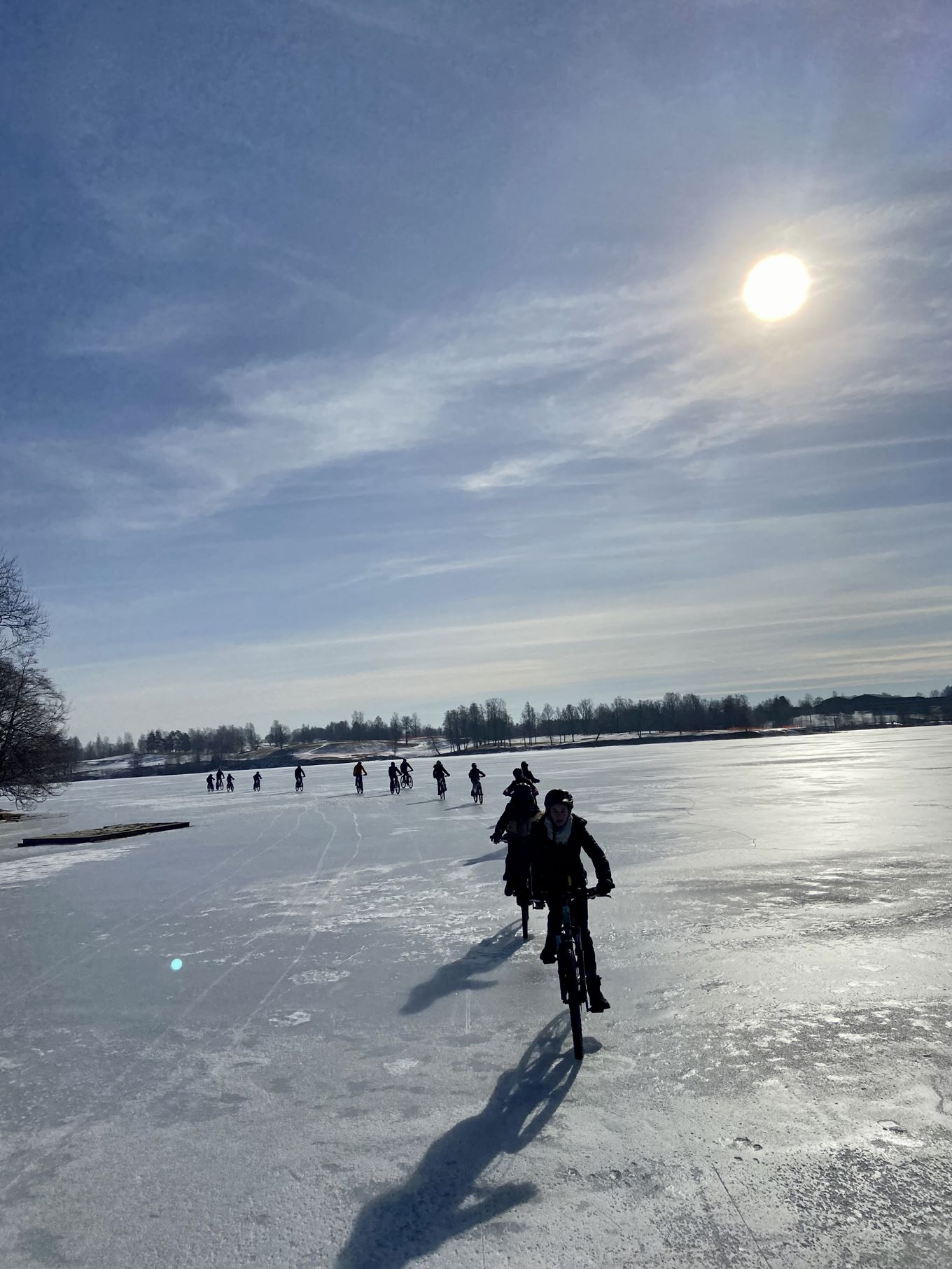 En gruppe mennesker som sykler på en snødekt vei