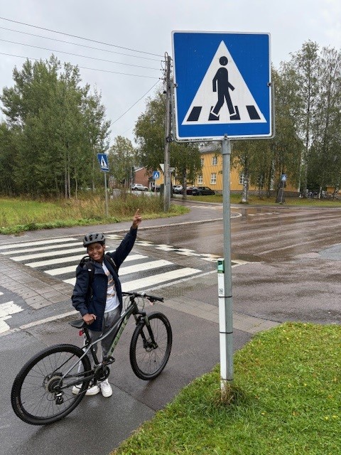 en person på sykkel som peker på et skilt