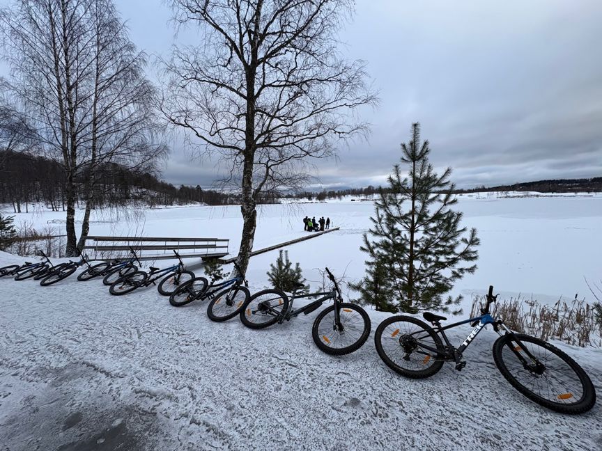 En gruppe sykler parkert ved en innsjø