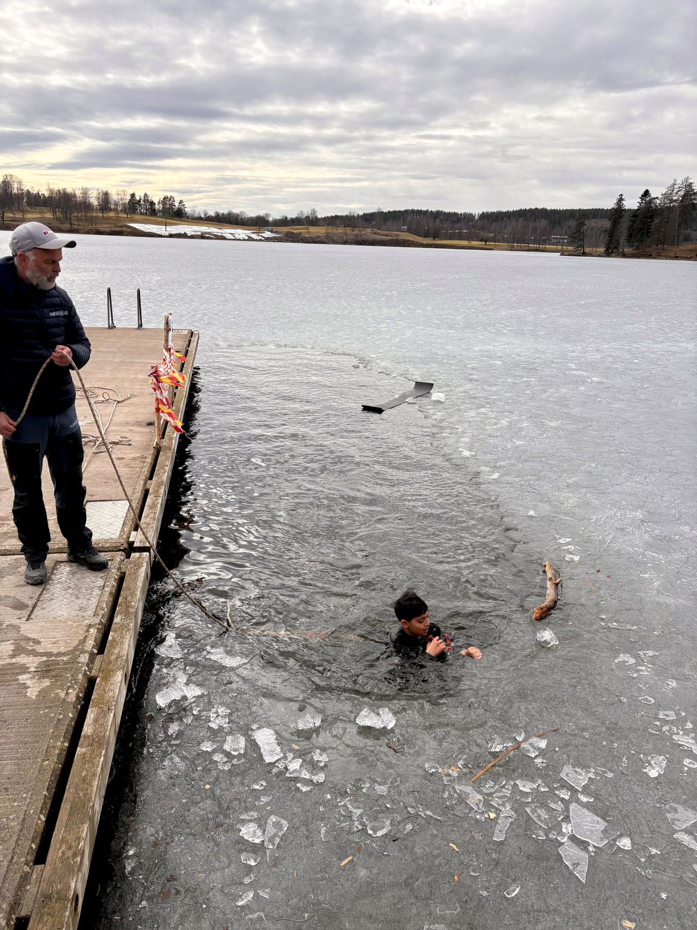 En person og et barn som fisker i en innsjø En person og et barn som fisker i en innsjø