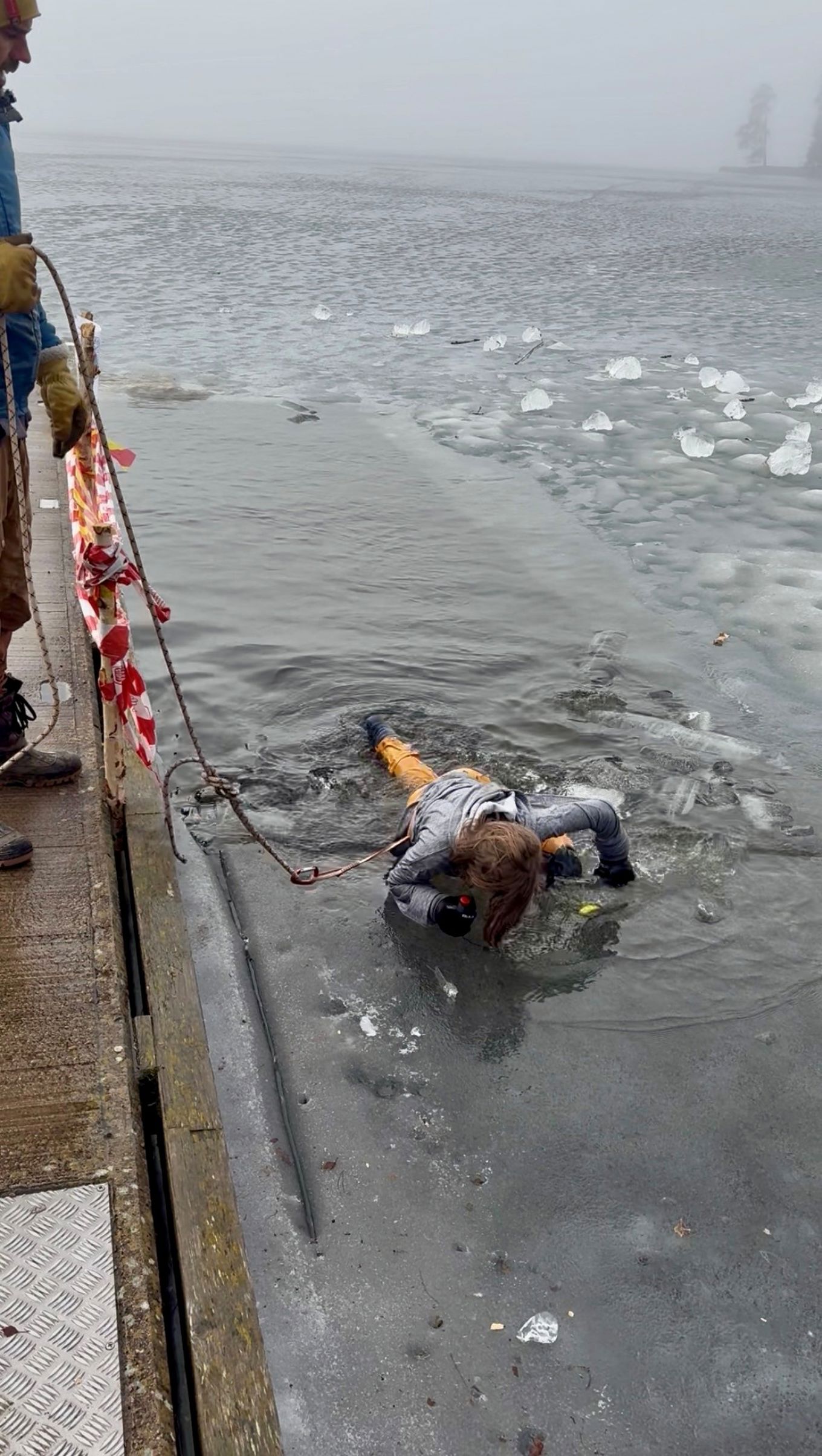 en person som lå på bakken ved siden av et vann en person som lå på bakken ved siden av et vann
